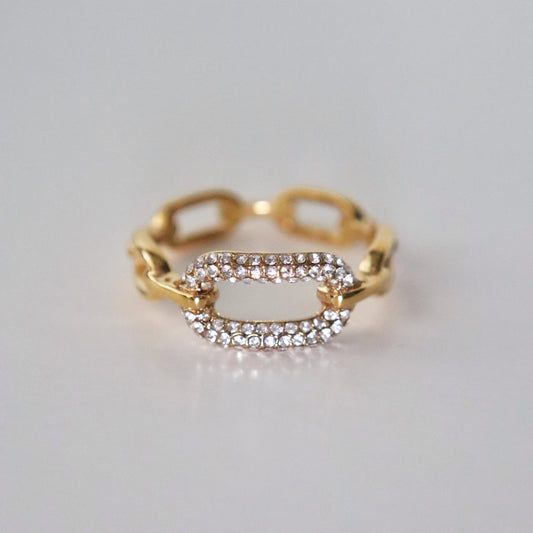 Gold ring with diamond accents on a light gray background
