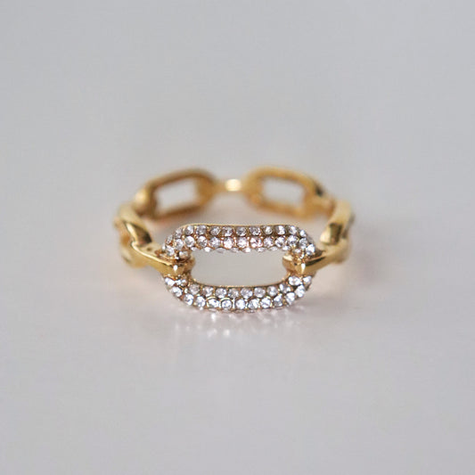 Gold ring with diamond accents on a light gray background